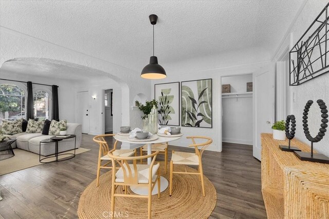 dining room featuring a textured ceiling and dark hardwood / wood-style flooring