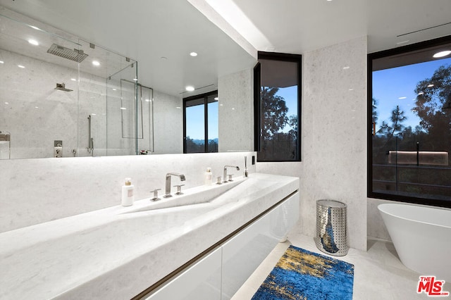 bathroom with vanity, independent shower and bath, and expansive windows