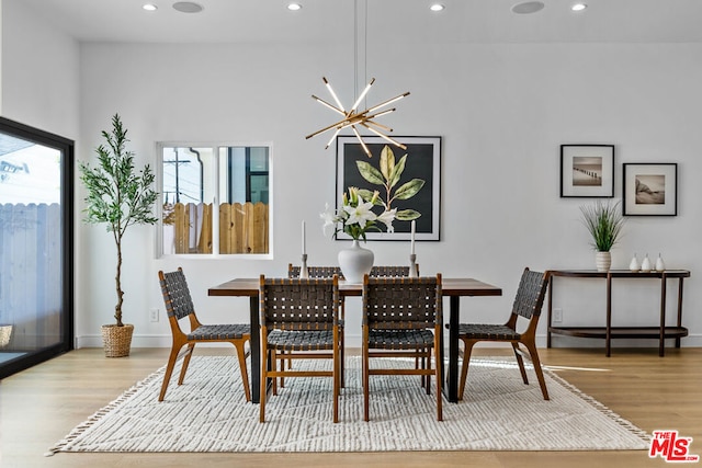 dining room with light hardwood / wood-style flooring and a chandelier