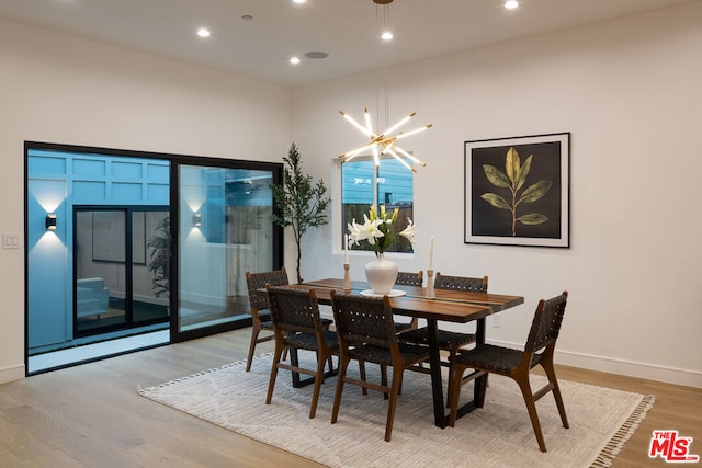 dining space featuring light hardwood / wood-style floors and a notable chandelier