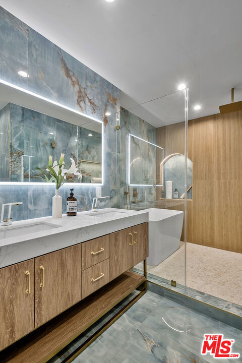 bathroom featuring tile walls, walk in shower, and vanity