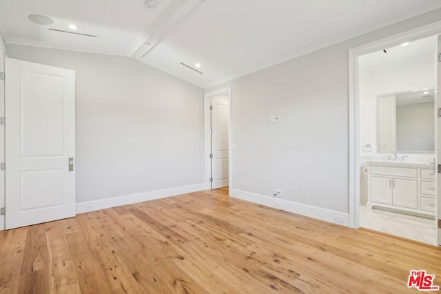 unfurnished bedroom featuring sink, connected bathroom, light hardwood / wood-style flooring, and lofted ceiling with beams