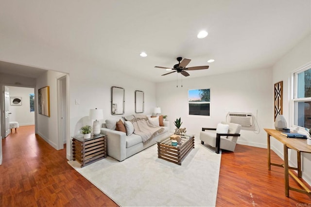 living room featuring ceiling fan, a wall unit AC, and hardwood / wood-style flooring