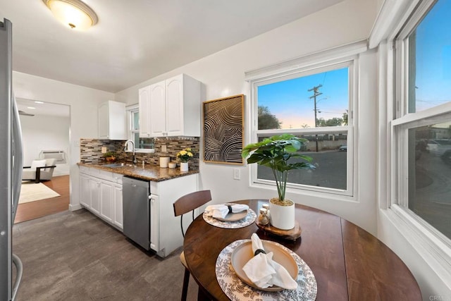 kitchen featuring white cabinets, appliances with stainless steel finishes, dark stone counters, tasteful backsplash, and sink