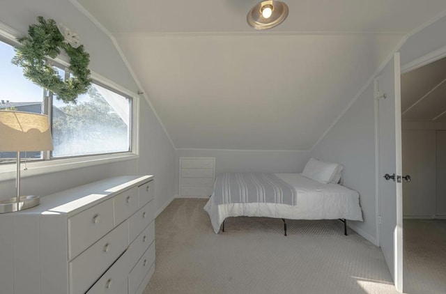 unfurnished bedroom featuring light carpet and lofted ceiling