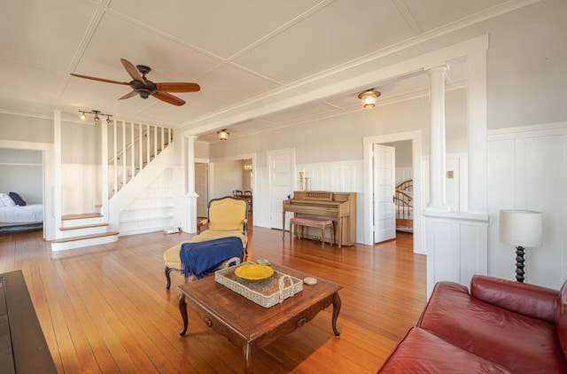 living room with ornamental molding, wood-type flooring, decorative columns, and ceiling fan