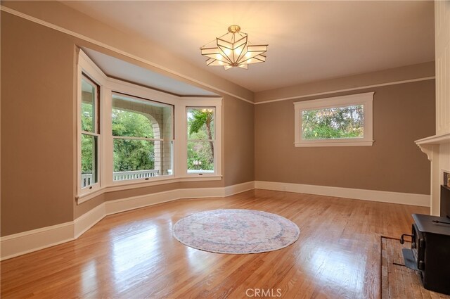 interior space with light wood-type flooring, an inviting chandelier, and a wood stove