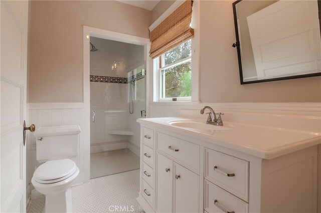 bathroom featuring toilet, tile patterned flooring, a shower with shower door, and vanity