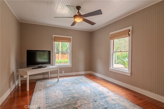 unfurnished office featuring hardwood / wood-style floors, crown molding, and a wealth of natural light