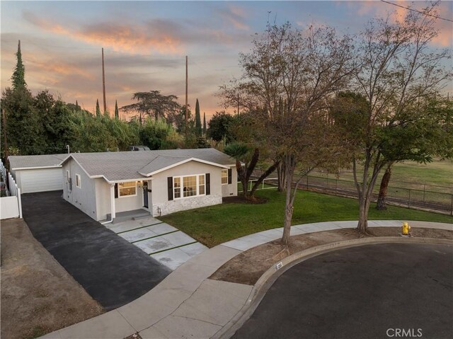 view of front of home with a garage and a lawn