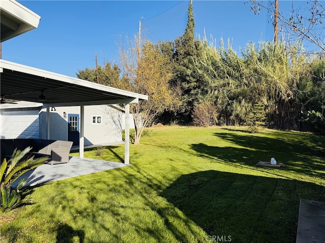 view of yard featuring ceiling fan and a patio area