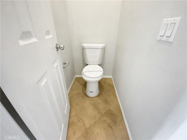 bathroom with baseboards and toilet