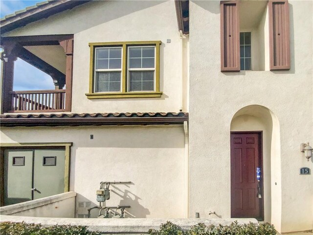 view of exterior entry with a balcony