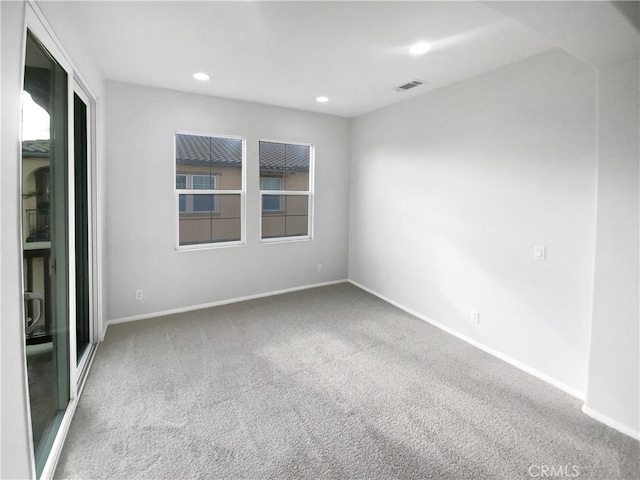 carpeted empty room featuring recessed lighting, visible vents, and baseboards