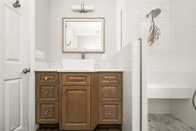 bathroom with vanity and a tile shower