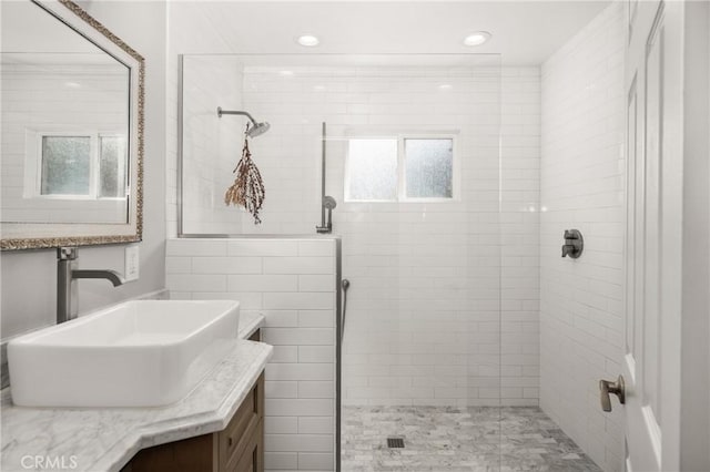 bathroom featuring vanity, plenty of natural light, and tiled shower