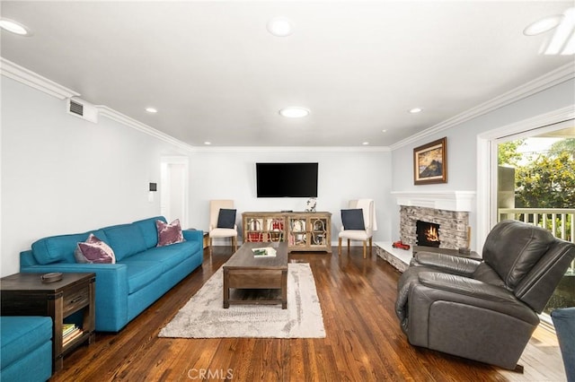 living room with dark hardwood / wood-style floors, ornamental molding, and a fireplace