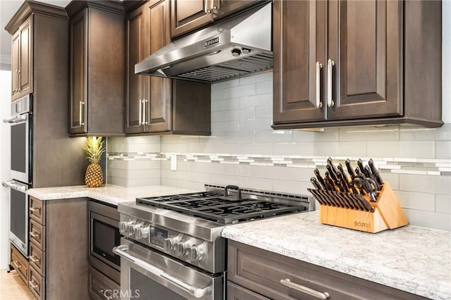 kitchen featuring appliances with stainless steel finishes, tasteful backsplash, and dark brown cabinetry