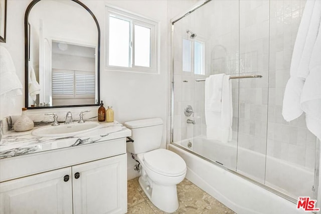 full bathroom with toilet, enclosed tub / shower combo, and vanity