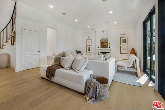 living room with ornamental molding and light hardwood / wood-style flooring