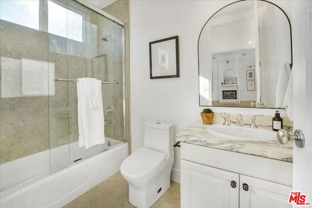 full bathroom with toilet, vanity, and shower / bath combination with glass door