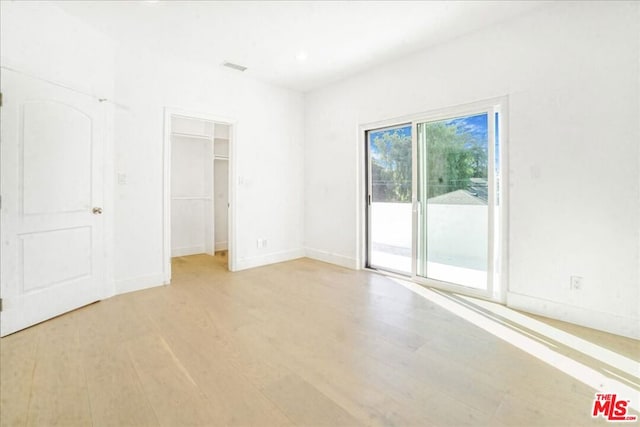 empty room with light hardwood / wood-style flooring