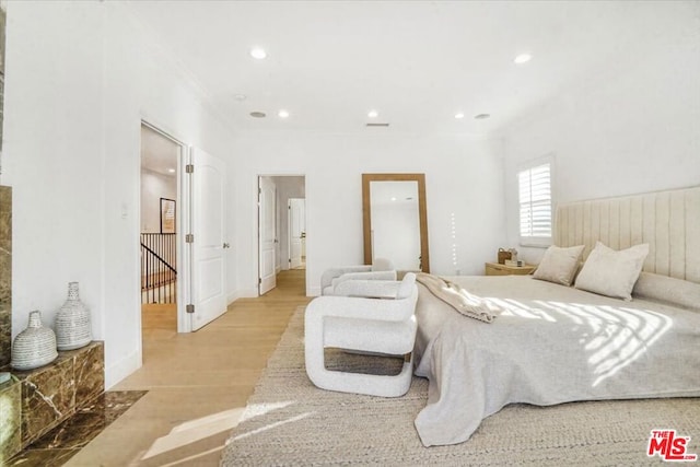 bedroom featuring light wood-type flooring and ornamental molding