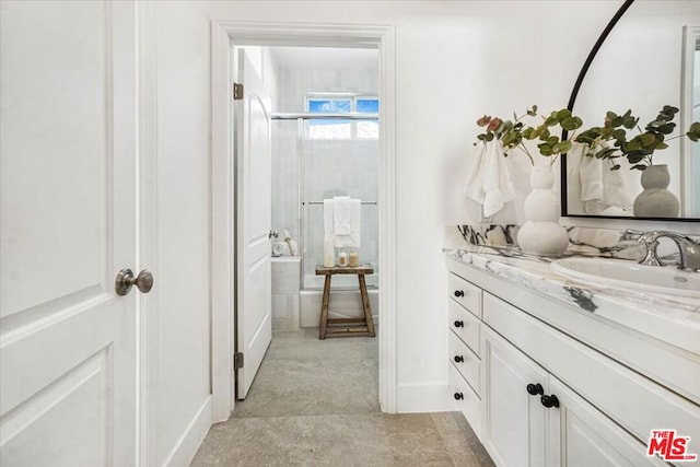 bathroom featuring vanity and a shower with door