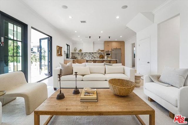 living room featuring crown molding and plenty of natural light