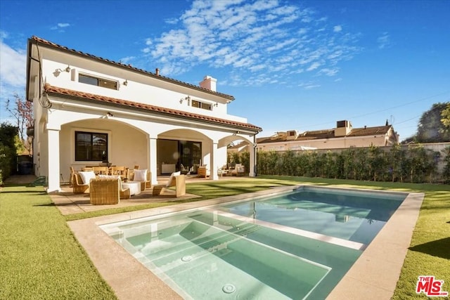 rear view of property with an outdoor living space, a yard, a patio, and a fenced in pool