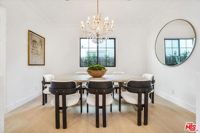 dining space with a notable chandelier, crown molding, and light hardwood / wood-style flooring