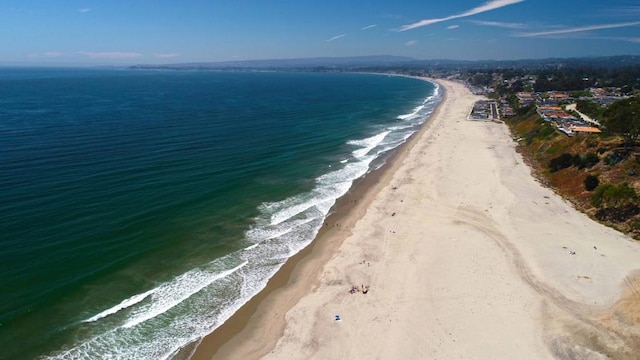 drone / aerial view with a beach view and a water view