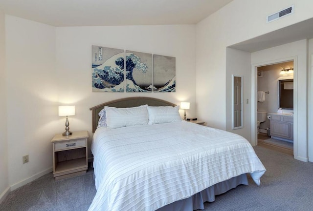 carpeted bedroom featuring ensuite bathroom and lofted ceiling