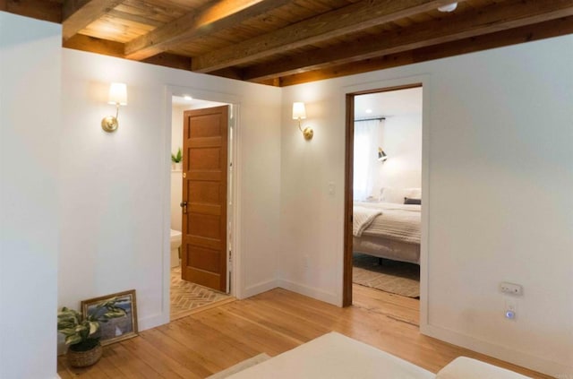 hall with beam ceiling, wood ceiling, and light hardwood / wood-style floors