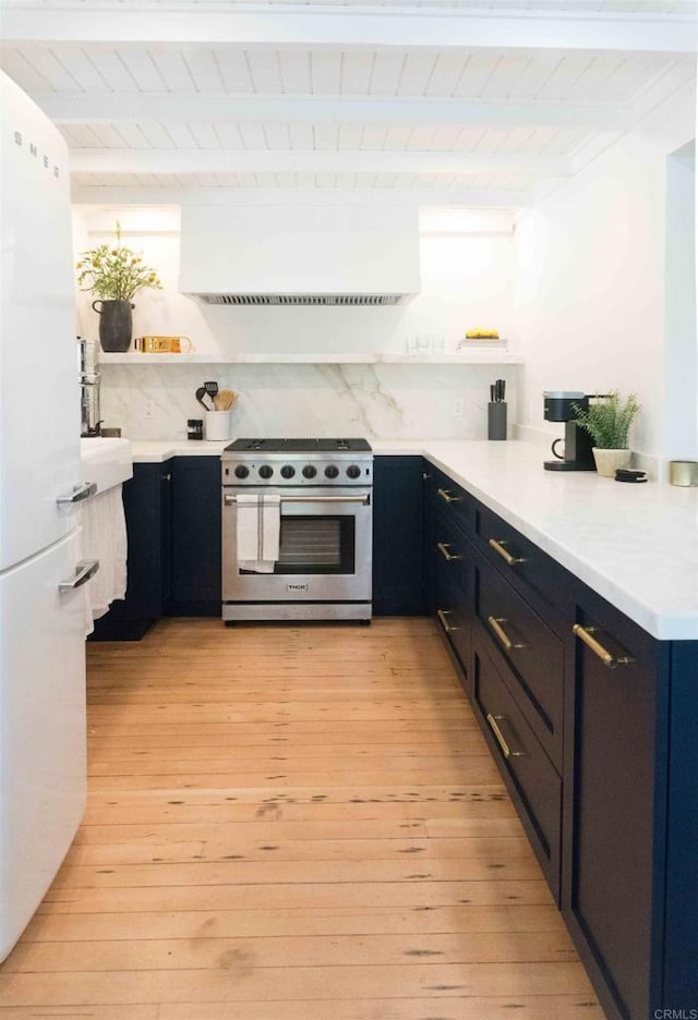 kitchen featuring high end stainless steel range, white refrigerator, beamed ceiling, and tasteful backsplash