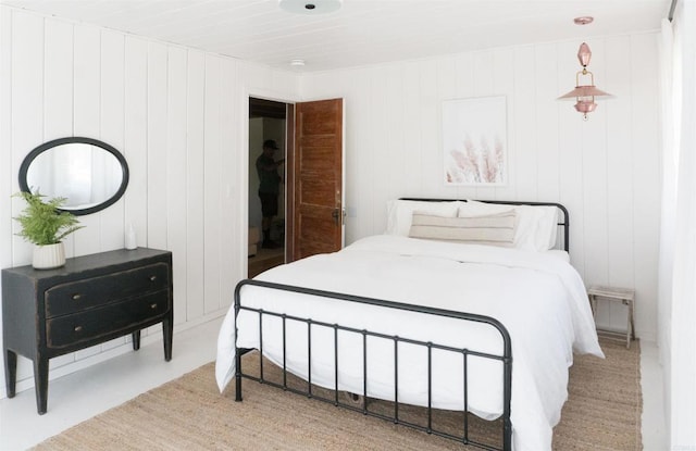 bedroom featuring wood walls