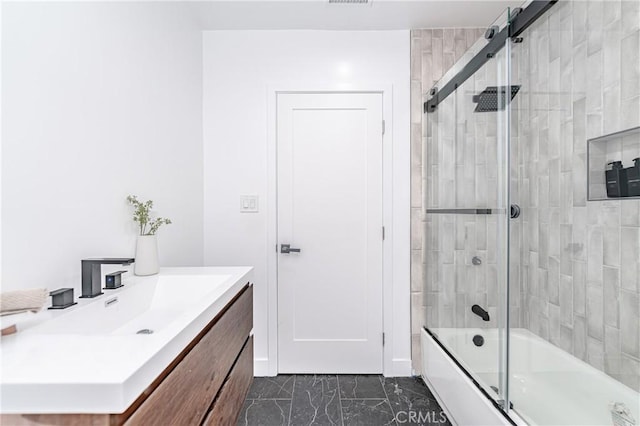 bathroom with vanity and bath / shower combo with glass door