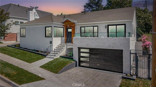 view of front of property featuring a balcony and a garage