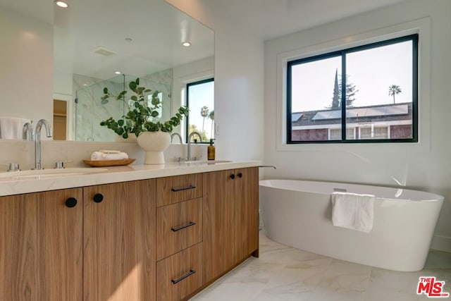 bathroom with vanity and shower with separate bathtub