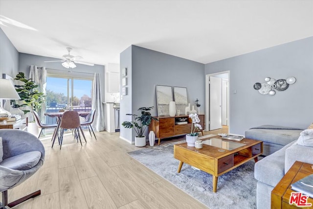 living room featuring ceiling fan and light hardwood / wood-style floors