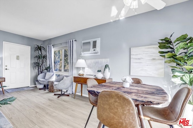 dining room featuring ceiling fan, a wall mounted air conditioner, and light wood-type flooring