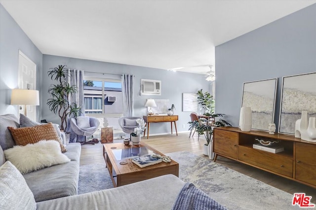 living room featuring ceiling fan, hardwood / wood-style floors, and a wall mounted air conditioner