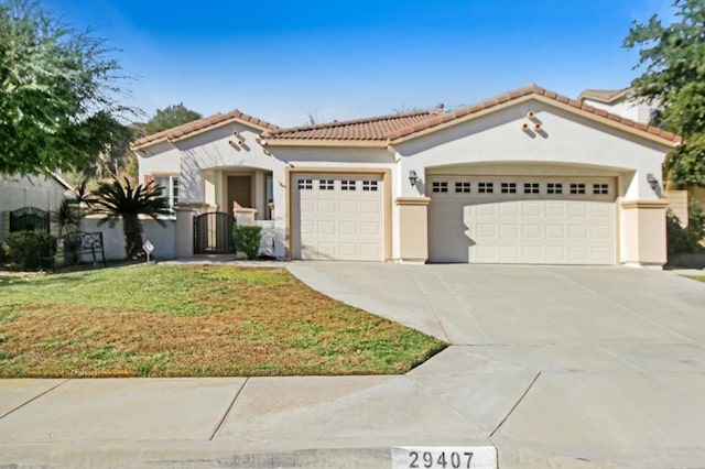 mediterranean / spanish-style house featuring a front yard and a garage