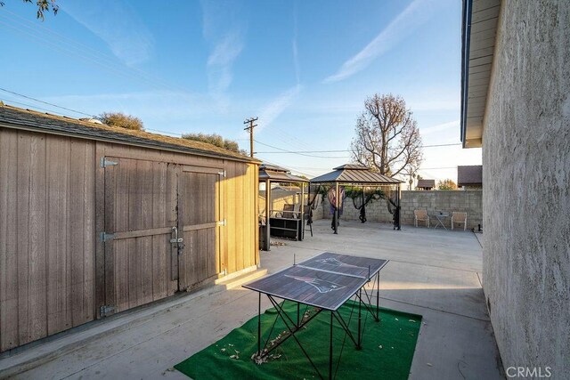 view of patio featuring a gazebo and a shed