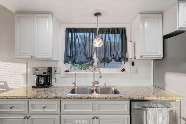 kitchen featuring backsplash, sink, and white cabinetry