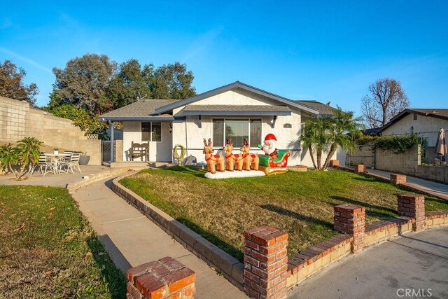 view of front of home featuring a front lawn and a patio