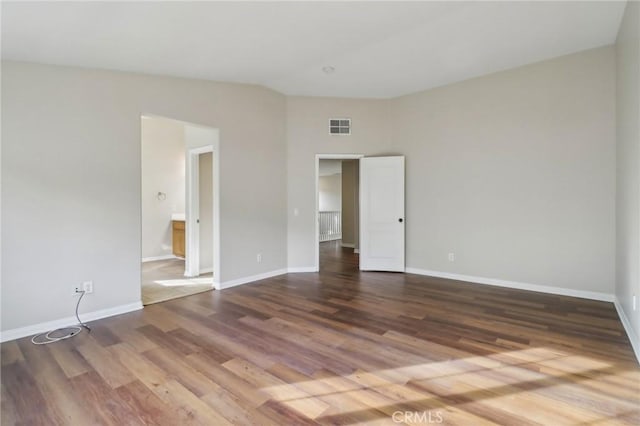 unfurnished room with wood-type flooring and vaulted ceiling