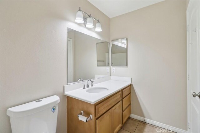 bathroom featuring toilet, vanity, and tile patterned flooring