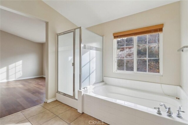 bathroom featuring tile patterned floors, independent shower and bath, and vaulted ceiling