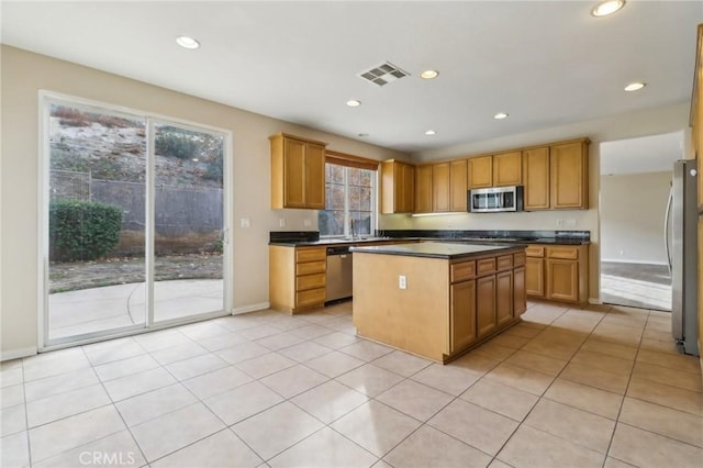 kitchen with light tile patterned floors, stainless steel appliances, and a kitchen island